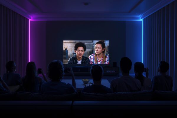 Group of friends watching TV in a dark room with neon purple and blue lighting
