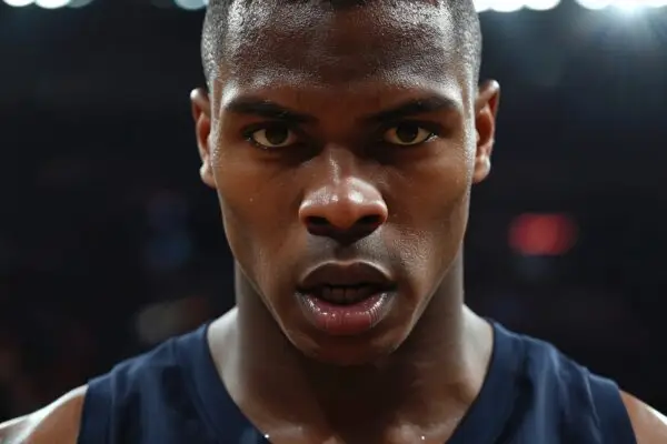 Close-up portrait of a focused NBA basketball player during a high-stakes playoff game, photorealistic editorial sports photo