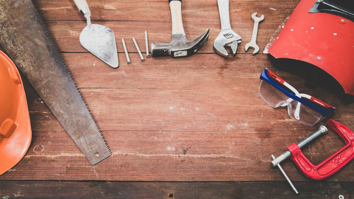 Hand tools flat lay for lawn mower repair - wrenches, sockets, and pliers used for spring tune-ups