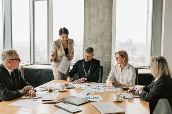 Diverse executive team in modern boardroom reviewing AI strategy