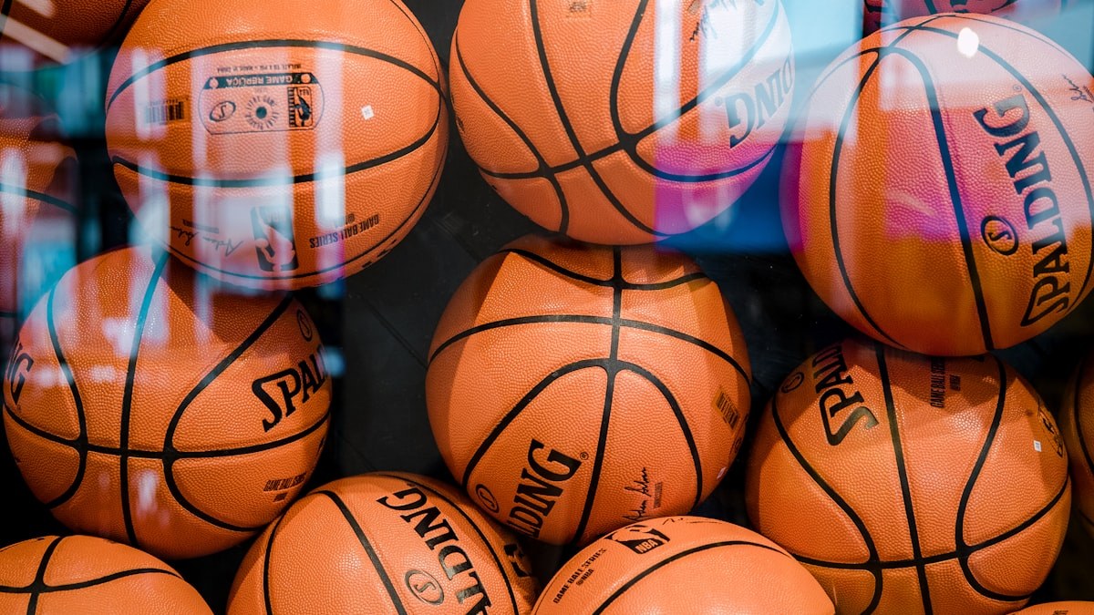 A basketball resting on the hardwood court of an empty arena