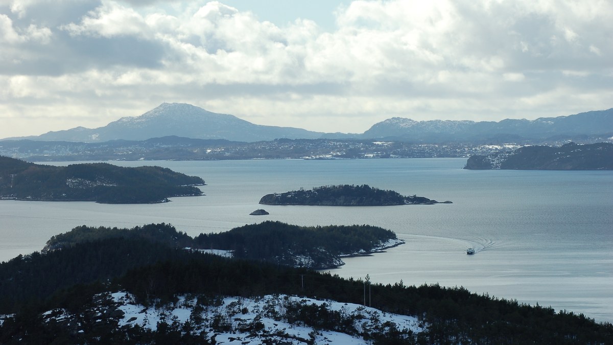 Sunlit Norwegian fjord framed by mountains