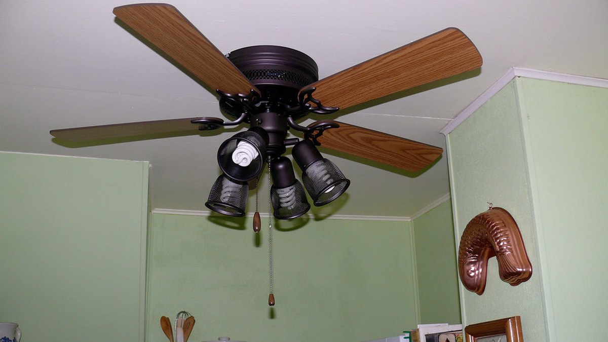 Ceiling fan with wood blades and light kit mounted in a kitchen
