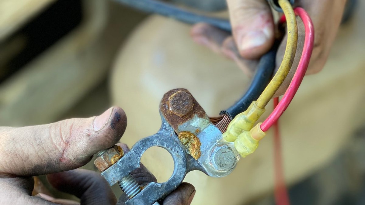 Close-up of a corroded car battery terminal clamp, a common cause of a car that clicks and won't start