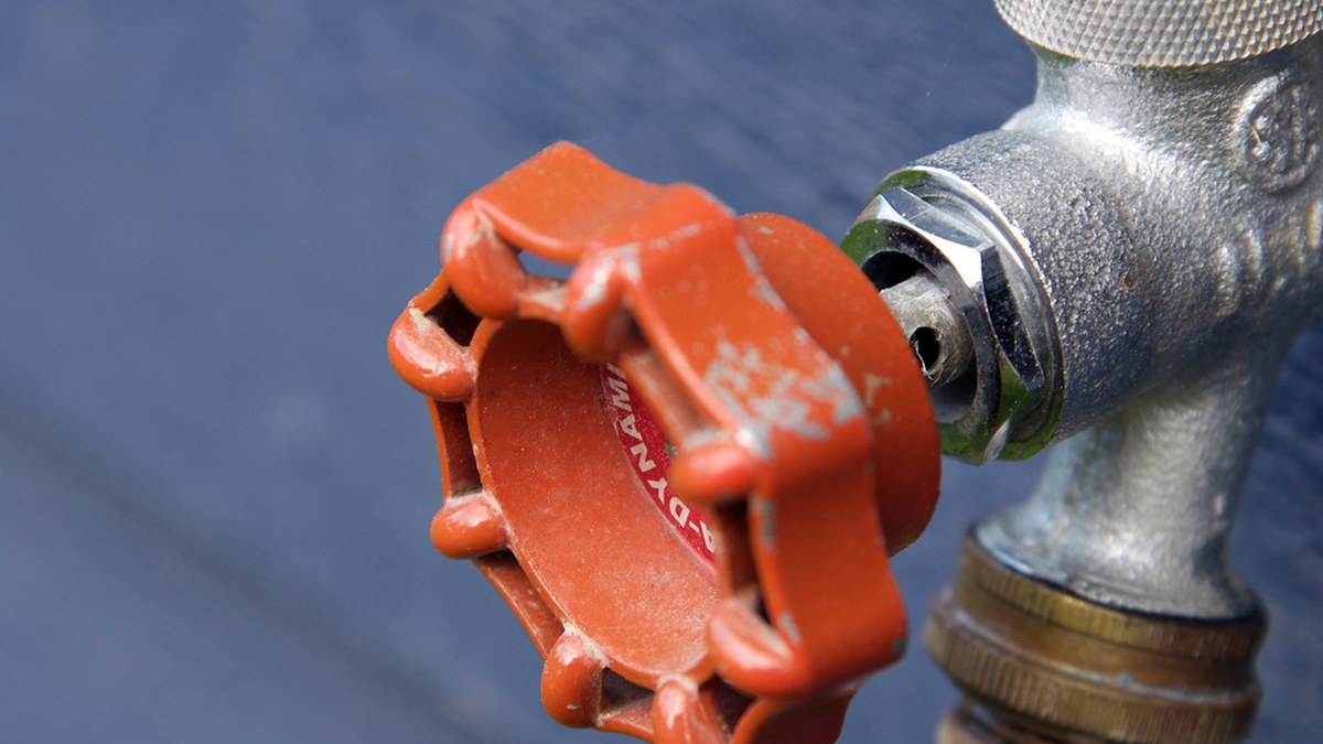 Close-up of a faucet valve stem and packing nut during a repair