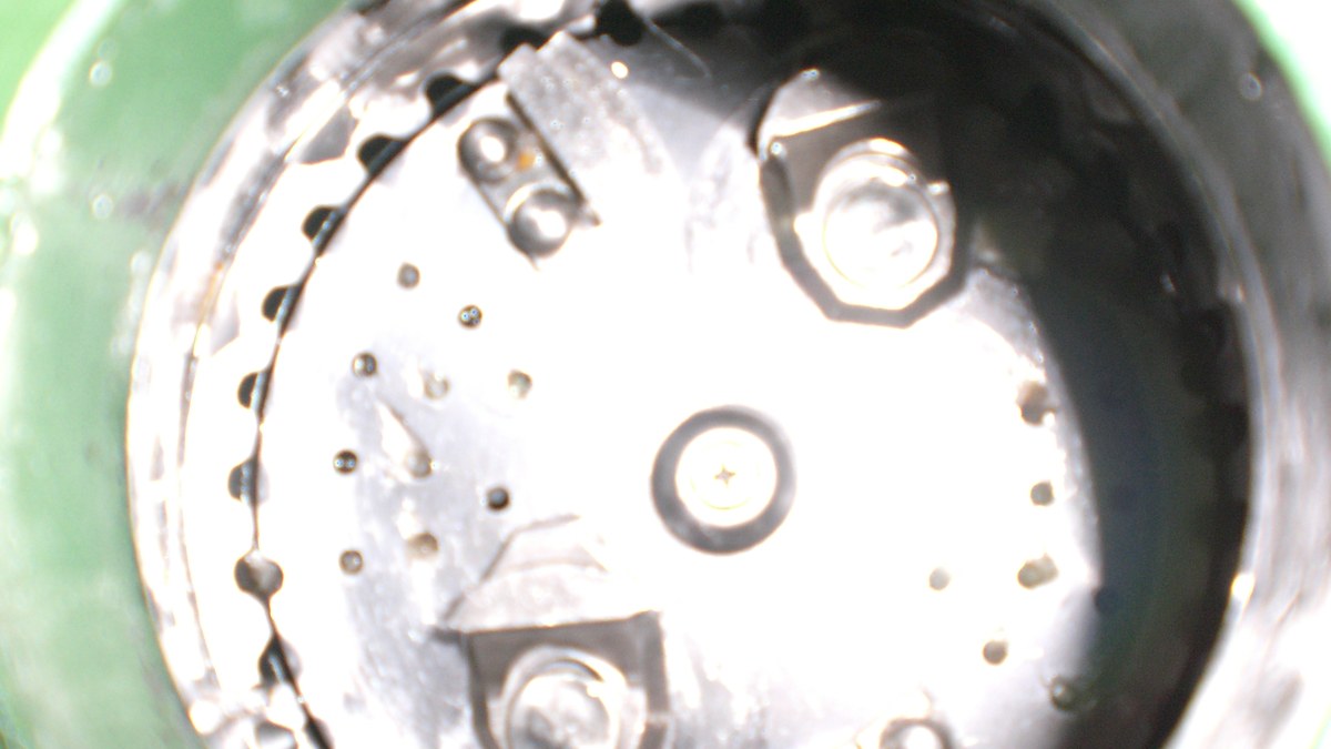 Looking inside a jammed garbage disposal chamber to remove debris