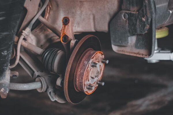 Rusty worn brake rotor and hub exposed during car brake grinding noise diagnosis