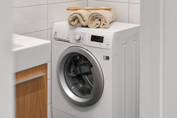 White front-load washing machine in a clean laundry room that is not spinning properly