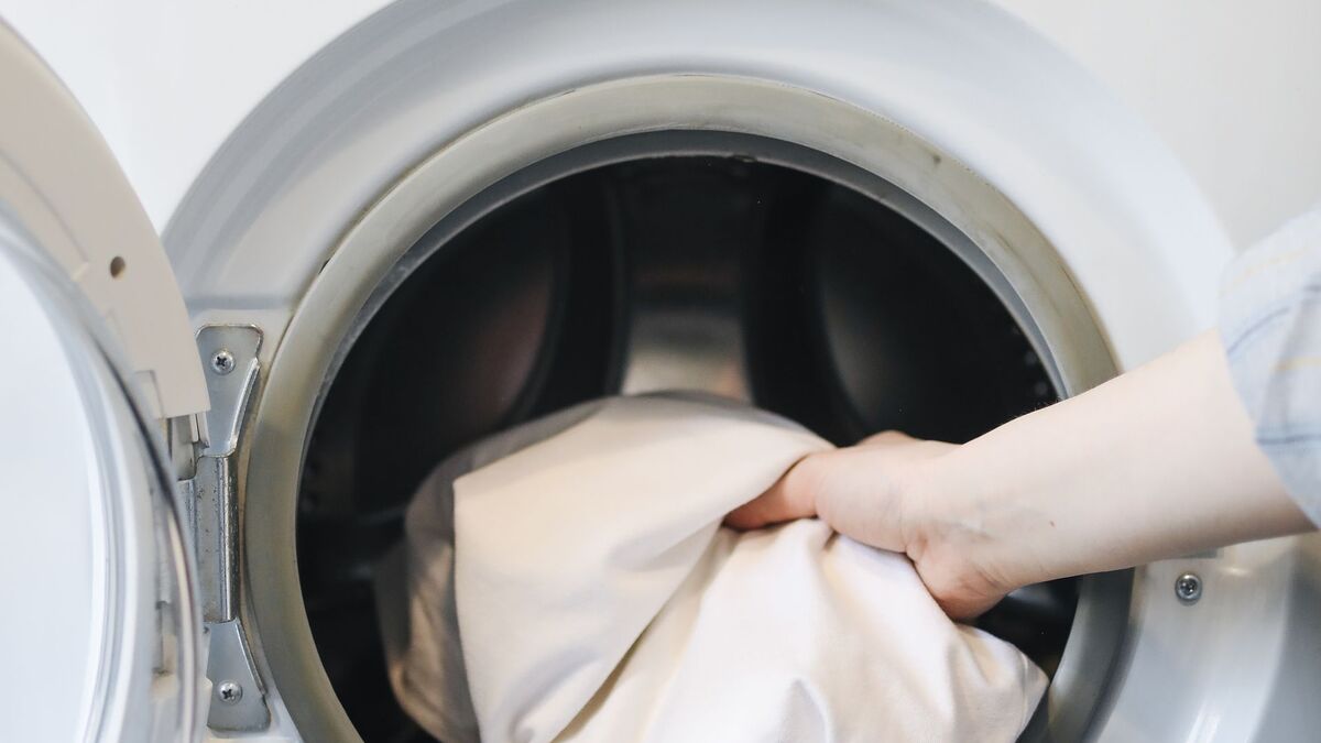 Person loading clothes into a washing machine that will not spin