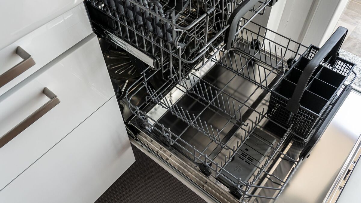Empty stainless steel dishwasher rack after a cleaning cycle