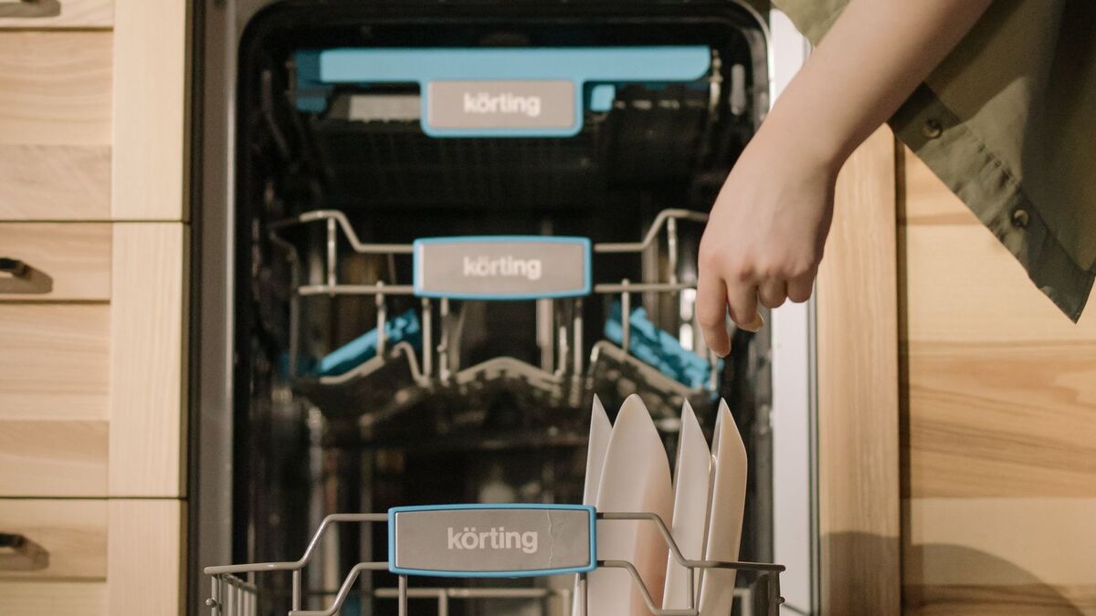 Person loading dishes into a dishwasher that is not cleaning properly